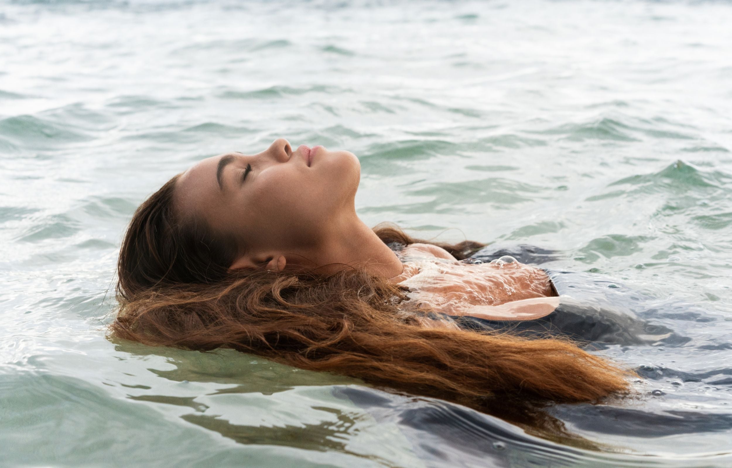 Woman relaxing in the ocean on her back