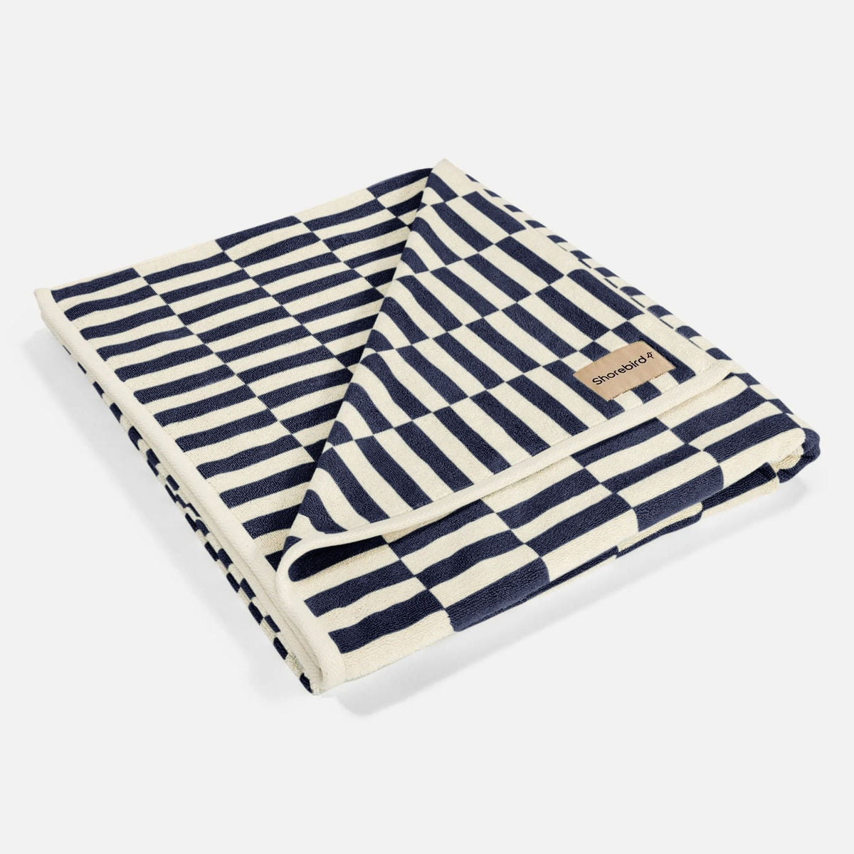 The Shorebird Oversized Beach Towel folded, showing the reversible navy check pattern #color_nantucket